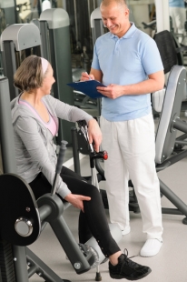 Physiotherapist assist active senior woman at gym