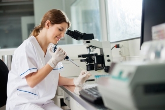 Researcher Using Pipette In Laboratory