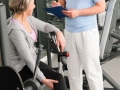 Physiotherapist assist active senior woman at gym