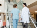 Doctor And Nurse Climbing Up Stairs In Hospital